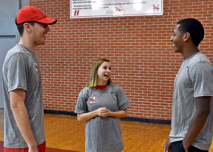 Cross country coach Dan August (left) and runners Ari Oldaker (center) and Milan Branch (right) talk during Wednesday's check-in. Cross country, men's and women's soccer and volleyball each reported for preseason practice.