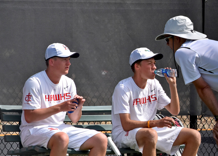 The No.3 team of Ben Marler (left) and Adam Self receive instructions from head coach Charlie Osten during their 8-4 doubles win on Wednesday. The Hawks won the overall match 7-2. (Photo by Wesley Lyle)